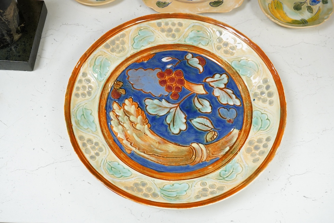 A collection of Doulton Brangwynware to include an oval dish, wall plate and two coffee cans and saucers, largest 32cm in diameter